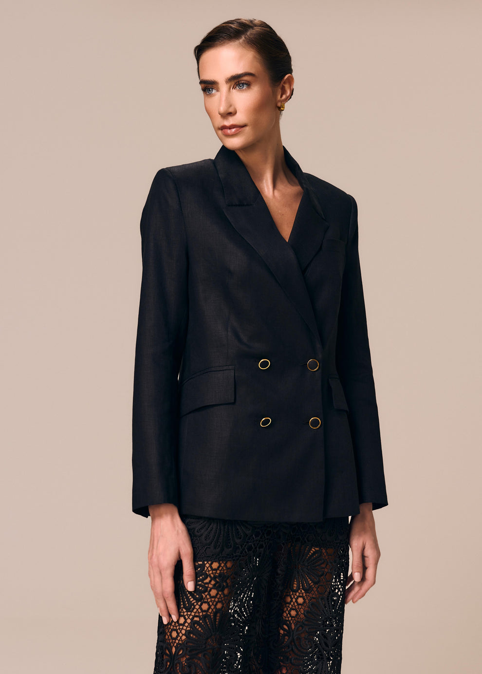 Detalhe do blazer feminino preto Essência La Gea com abotoamento duplo de botão forrado e bordas douradas
