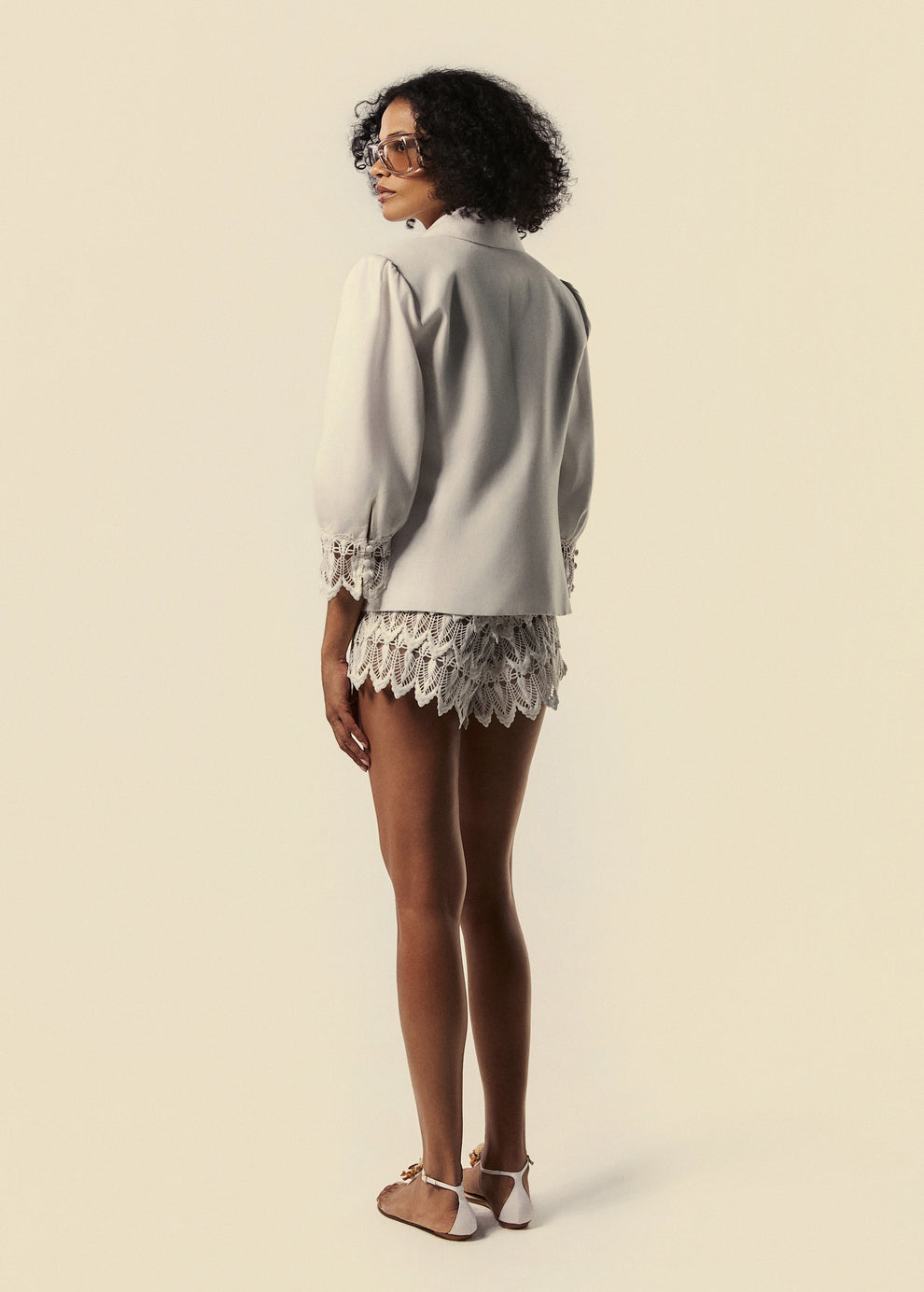 Modelo de costas combina blazer Elixir com short Florescer da La Gea.
