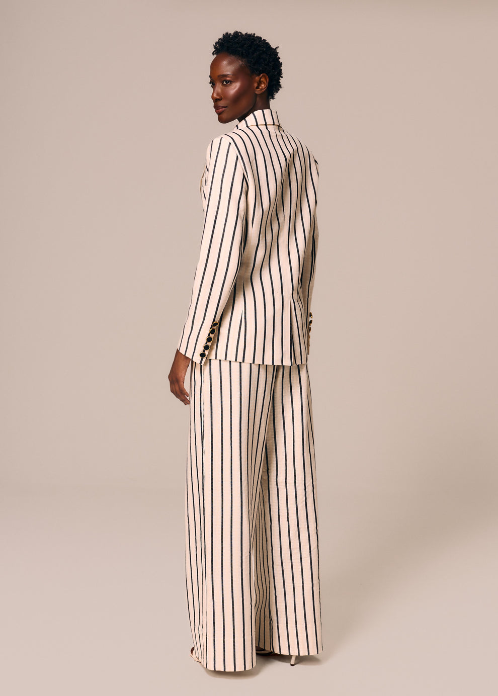 Detalhe costas do blazer e calça reta listrado off White e preto Eterno La Gea