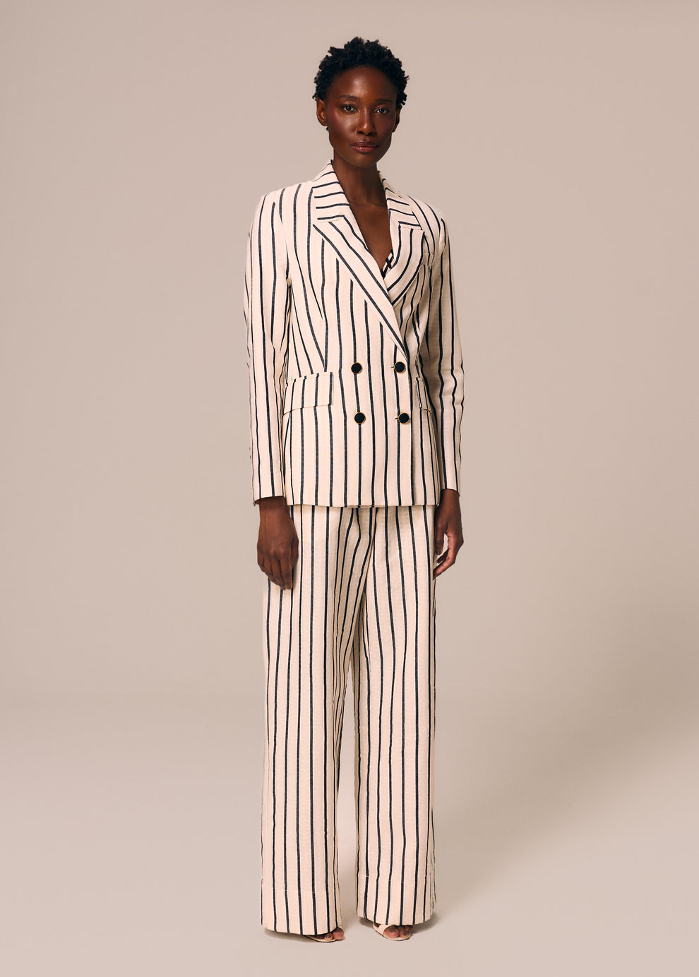 Modelo veste blazer e calça reta listrado off White e preto Eterno La Gea