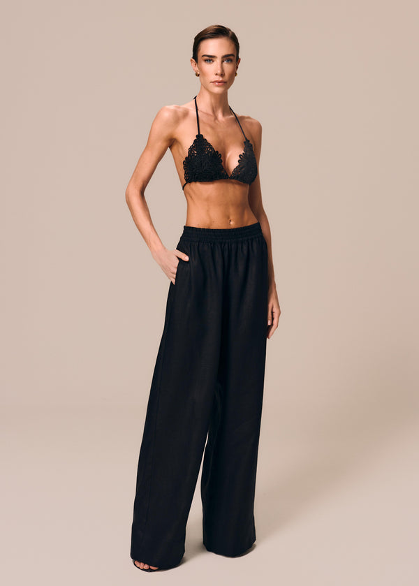 Modelo veste calça boxer preta Essência com top de biquíni cortininha Pedra La Gea