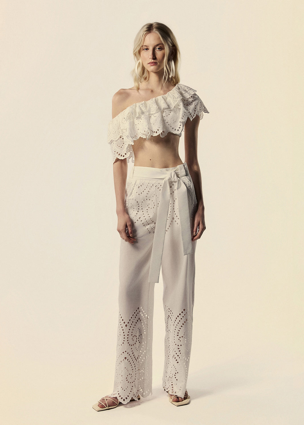 Modelo combina calça pantalona e top ombro só em laise branco família Lumina coleção de Verão da La Gea.