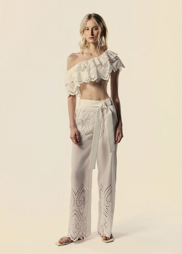 Modelo combina calça pantalona e top ombro só em laise branco família Lumina coleção de Verão da La Gea.