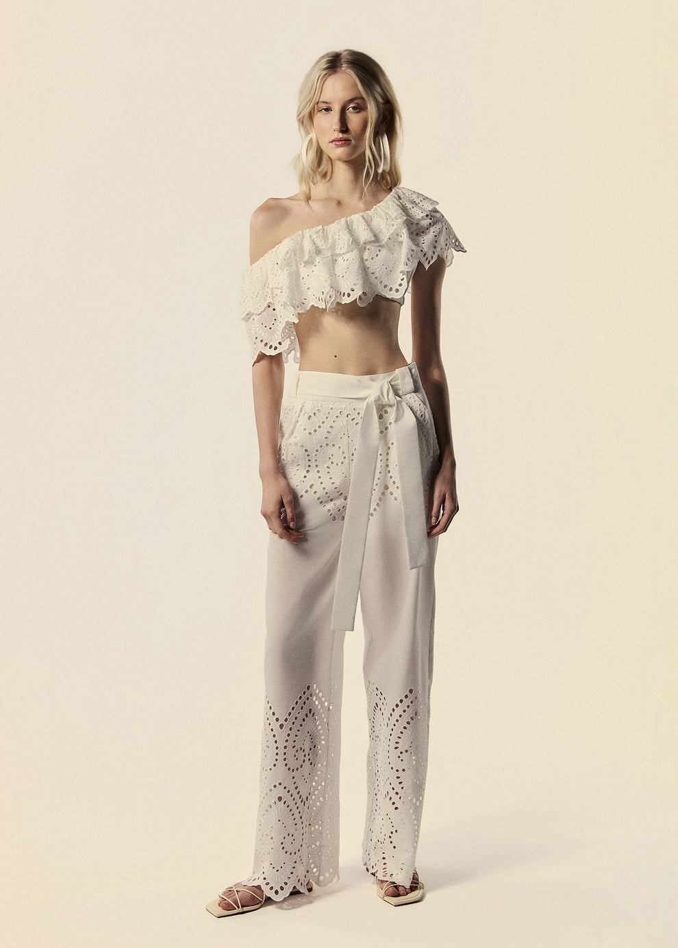 Modelo combina calça pantalona e top ombro só em laise branco família Lumina coleção de Verão da La Gea.