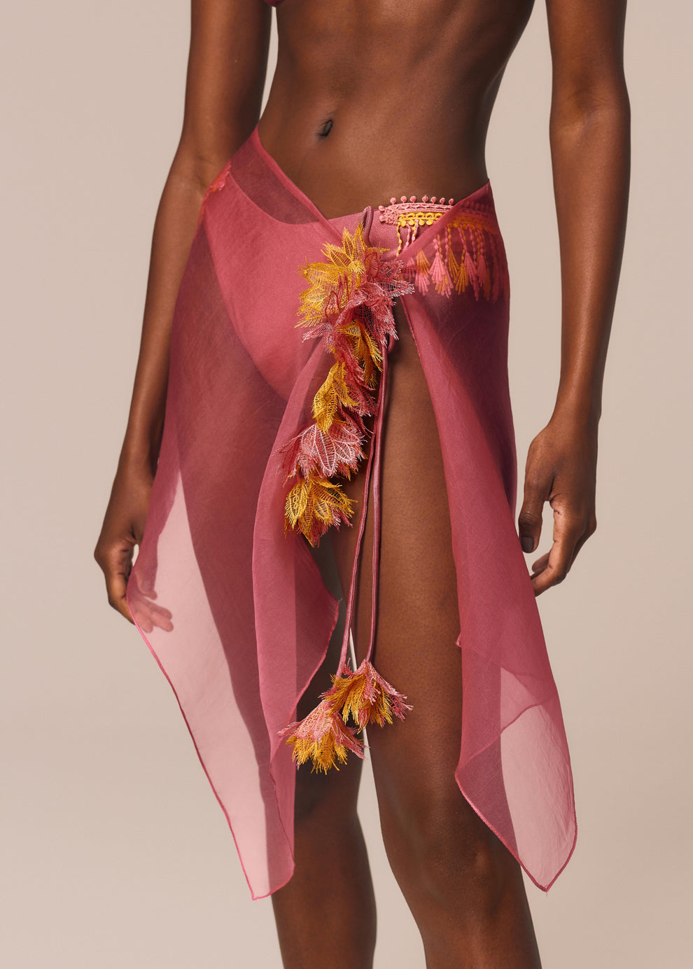 Detalhe próximo da calcinha slip Vibra e saia pareô curta de seda com flores em guipir da coleção de carnaval La Gea