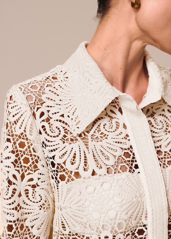 Detalhe da camisa feminina off white em renda Cerâmica La Gea com top de biquíni bandeau como forro