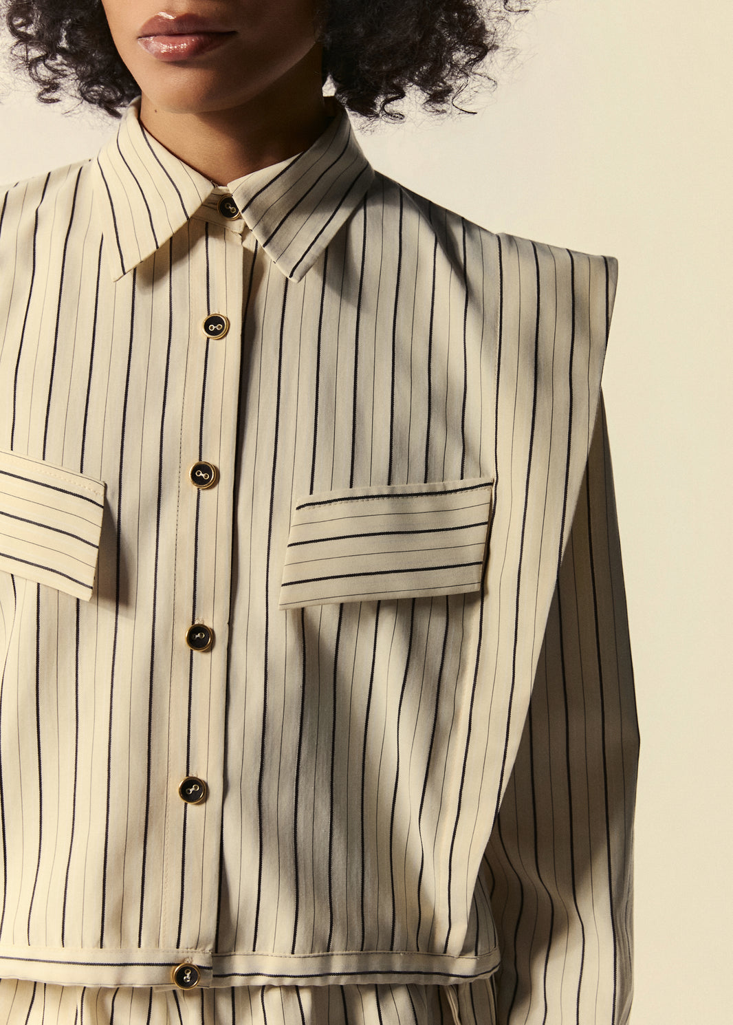 Detalhe da camisa curta feminina listrada da família Trópico.
