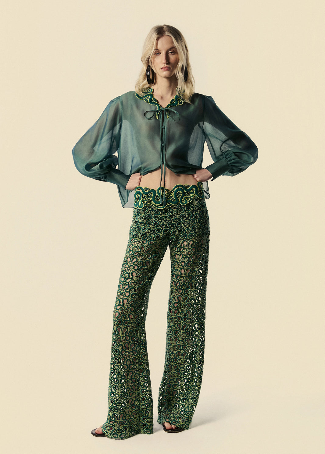 Modelo usa camisa feminina verde Destino com transparência e calça flare de renda Trilhas da coleção de Verão 27.