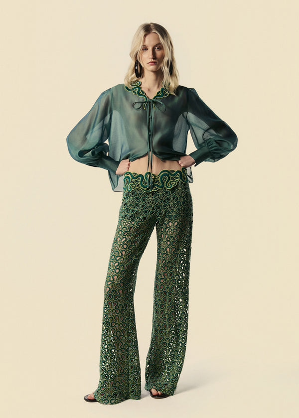 Modelo usa camisa feminina verde Destino com transparência e calça flare de renda Trilhas da coleção de Verão 27.
