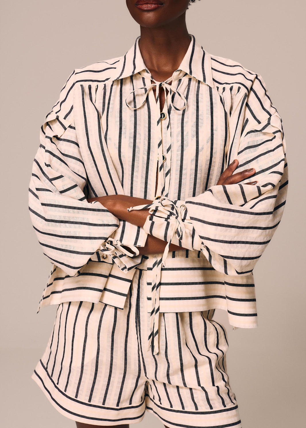 Detalhe da camisa feminina listrada off White e preto Eterno La Gea com amarração nos punhos