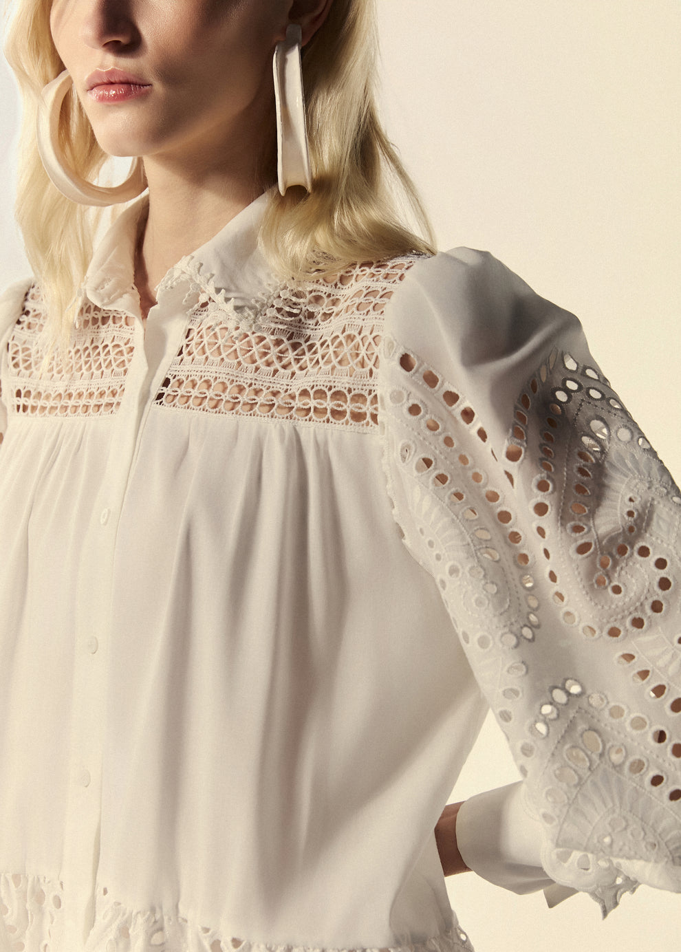 Detalhe da chemise curta da La Gea em laise de algodão branco bordado.