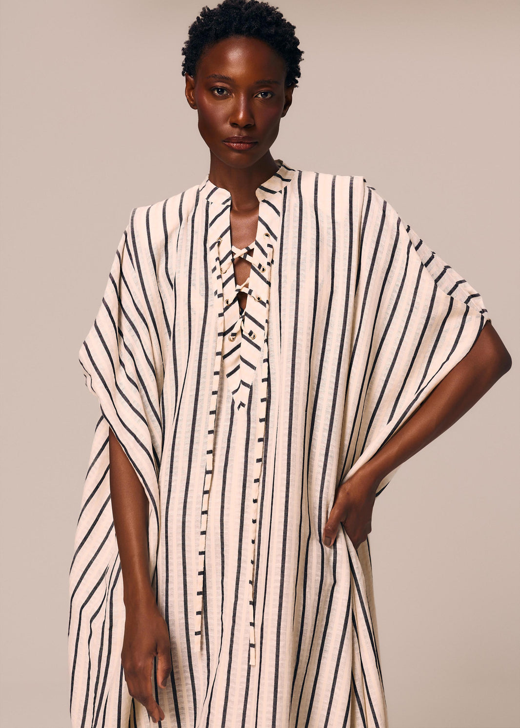 Detalhe frontal do kaftan longo listrado off White e preto Eterno La Gea com amarração no decote