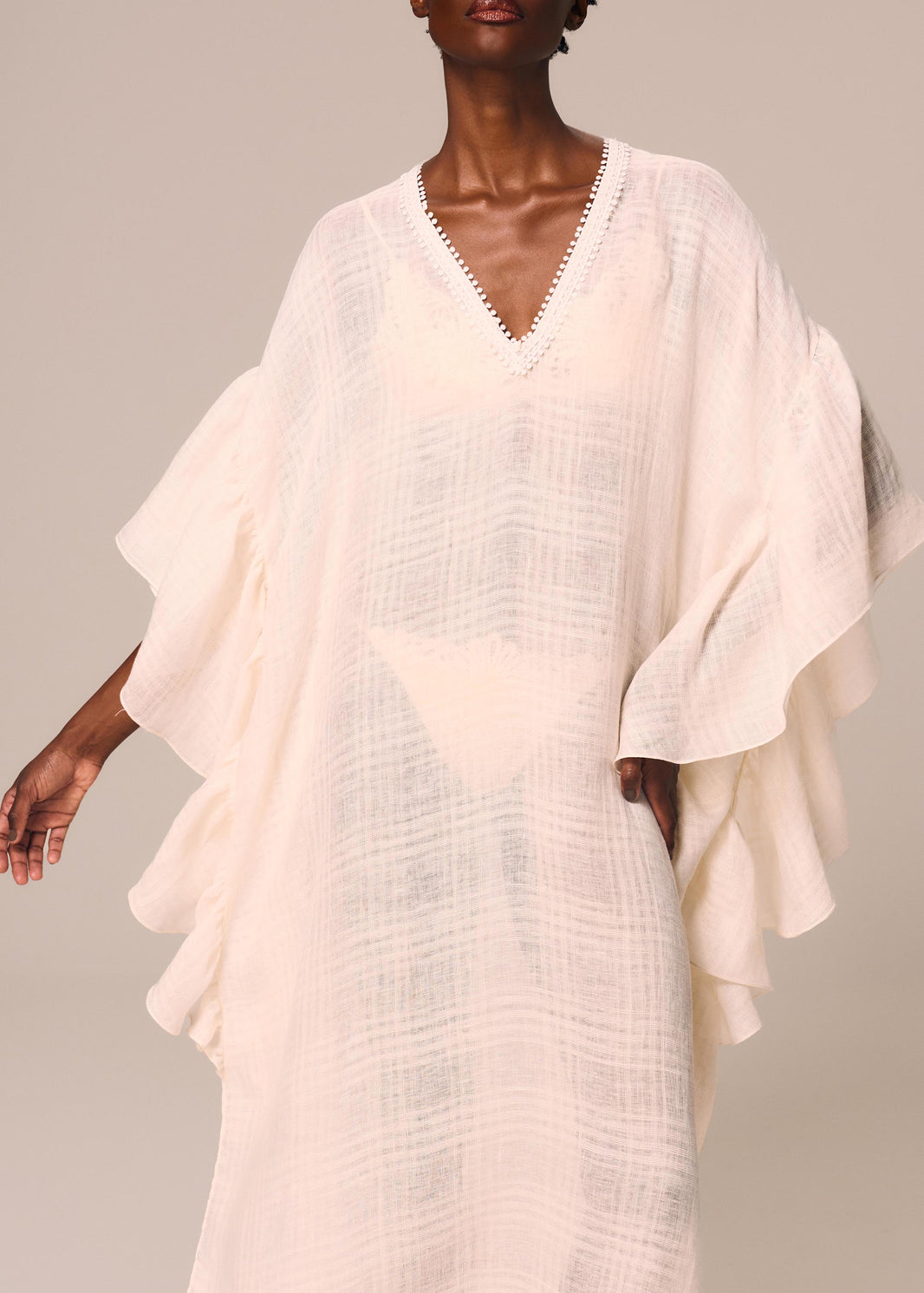 Detalhe do decote e babado na manga do kaftan longo Etéreo La Gea na cor off white