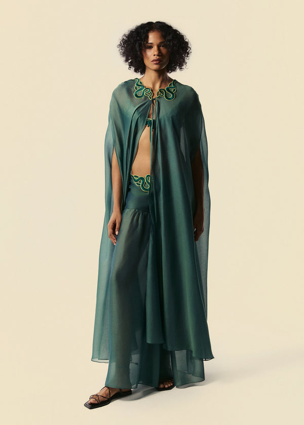 Modelo combina kaftan longo verde com calça pantalona Destino e top de biquíni triângulo Trincas do lançamento da La Gea.