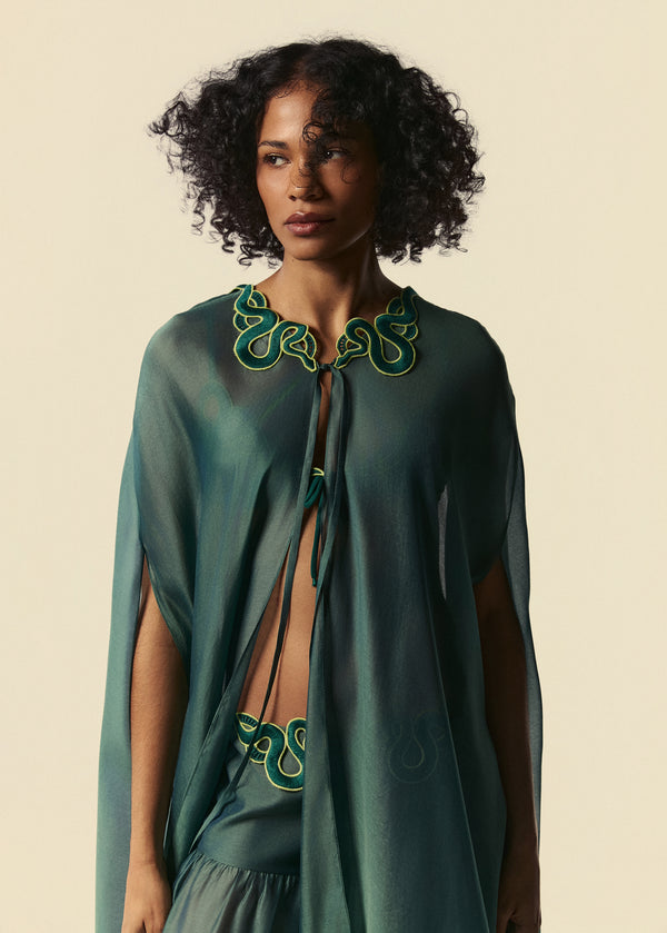 Detalhe do kaftan longo verde com aplicação de guipir de serpente no decote e calça pantalona Destino.