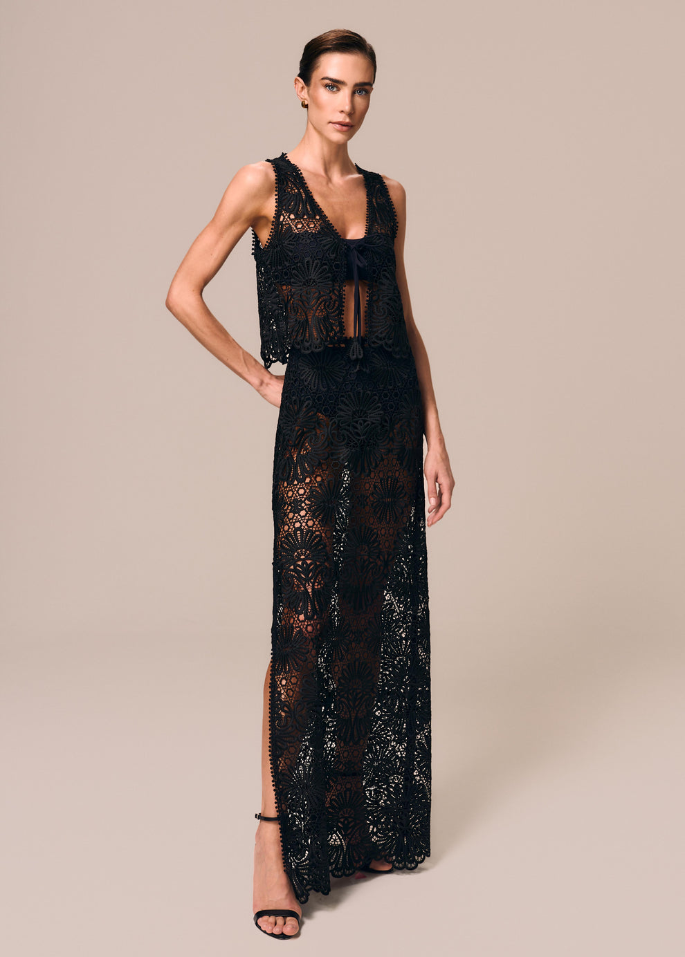 Modelo veste look preto de saia longa com fenda em renda Cerâmica La Gea com top de amarração