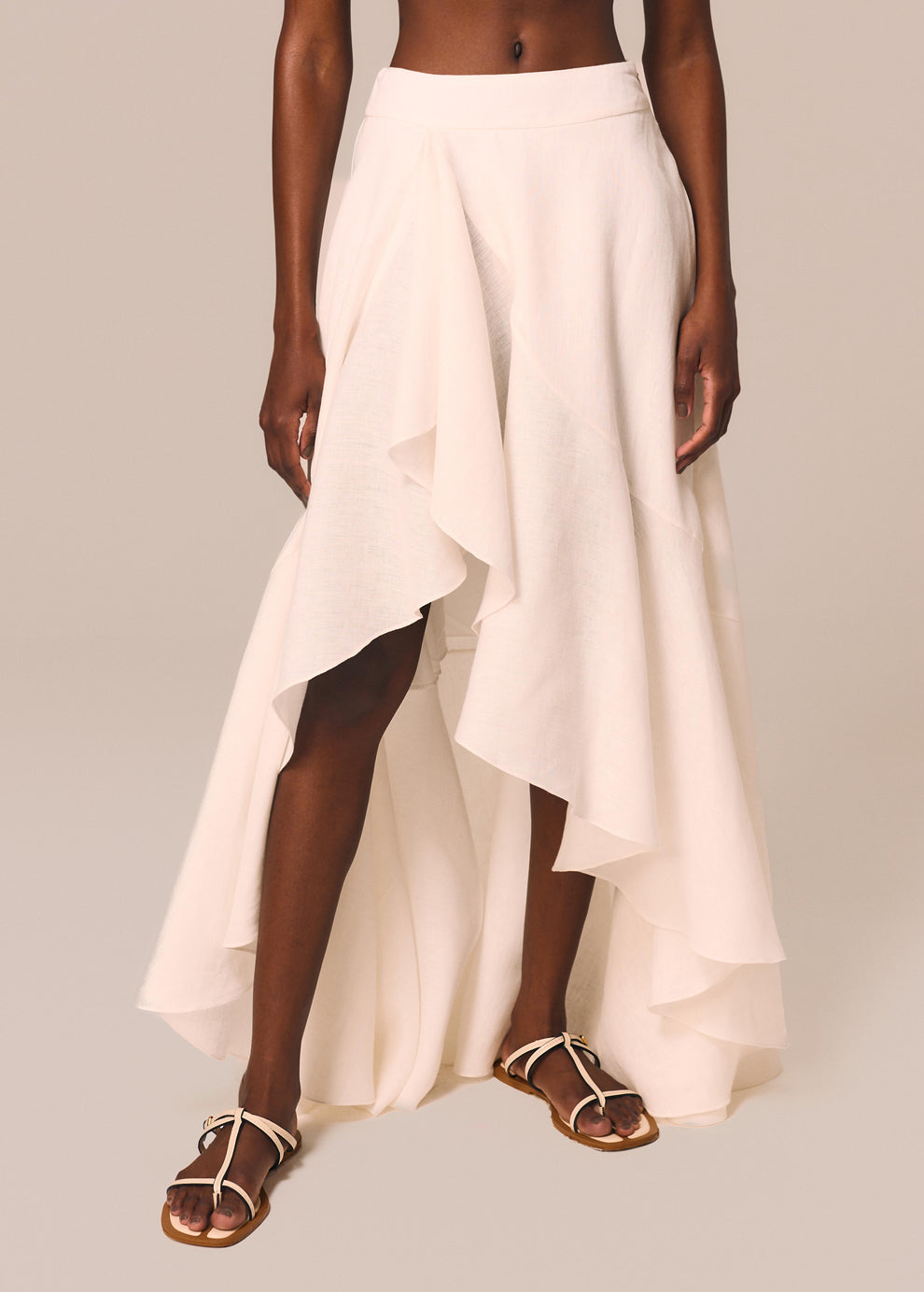 Detalhe da saia longa assimétrica com babado na fenda off White Essência La Gea