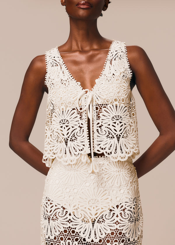 Detalhe do decote do top de amarração frontal em renda Cerâmica La Gea off white com top de biquíni bandeau básico