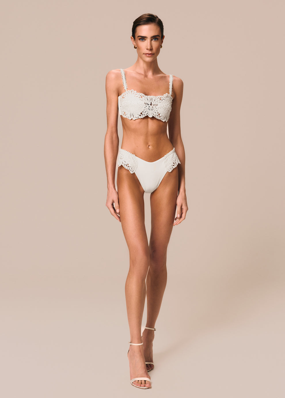 Modelo veste top de biquíni bandeau com renda Pedra La Gea off White e calcinha modelo slip