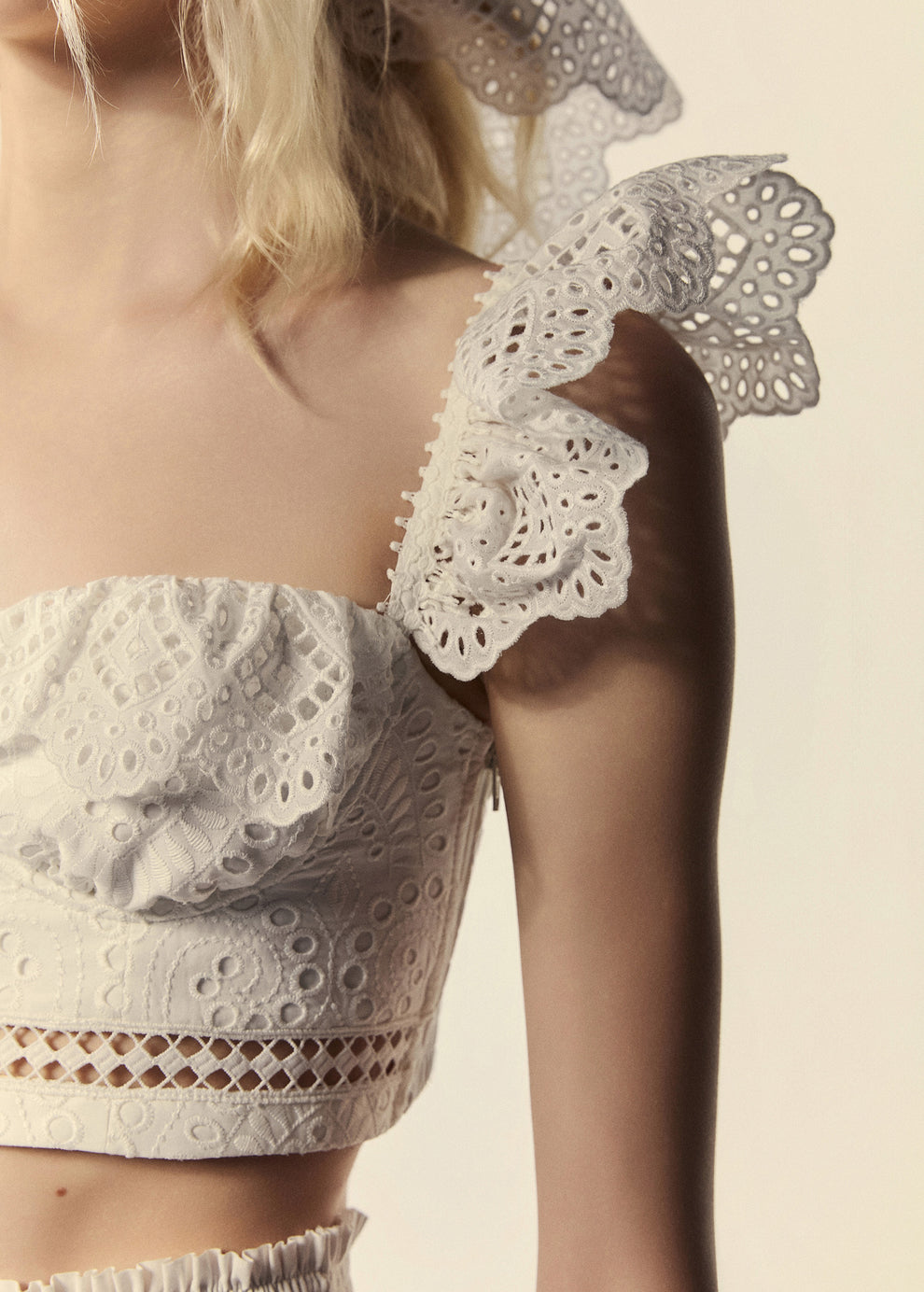 Detalhe da alça do top corset branco La Gea em laise de algodão bordado da família Lumina.