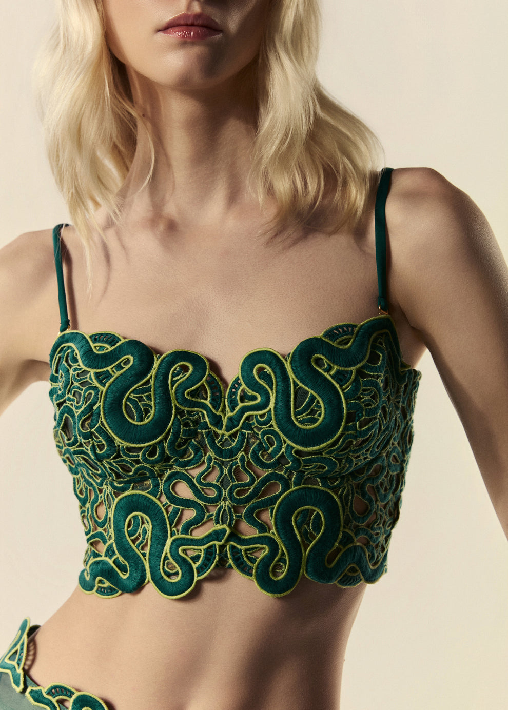 Detalhe do decote coração do top corset verde da coleção de Verão com desenhos de serpente.