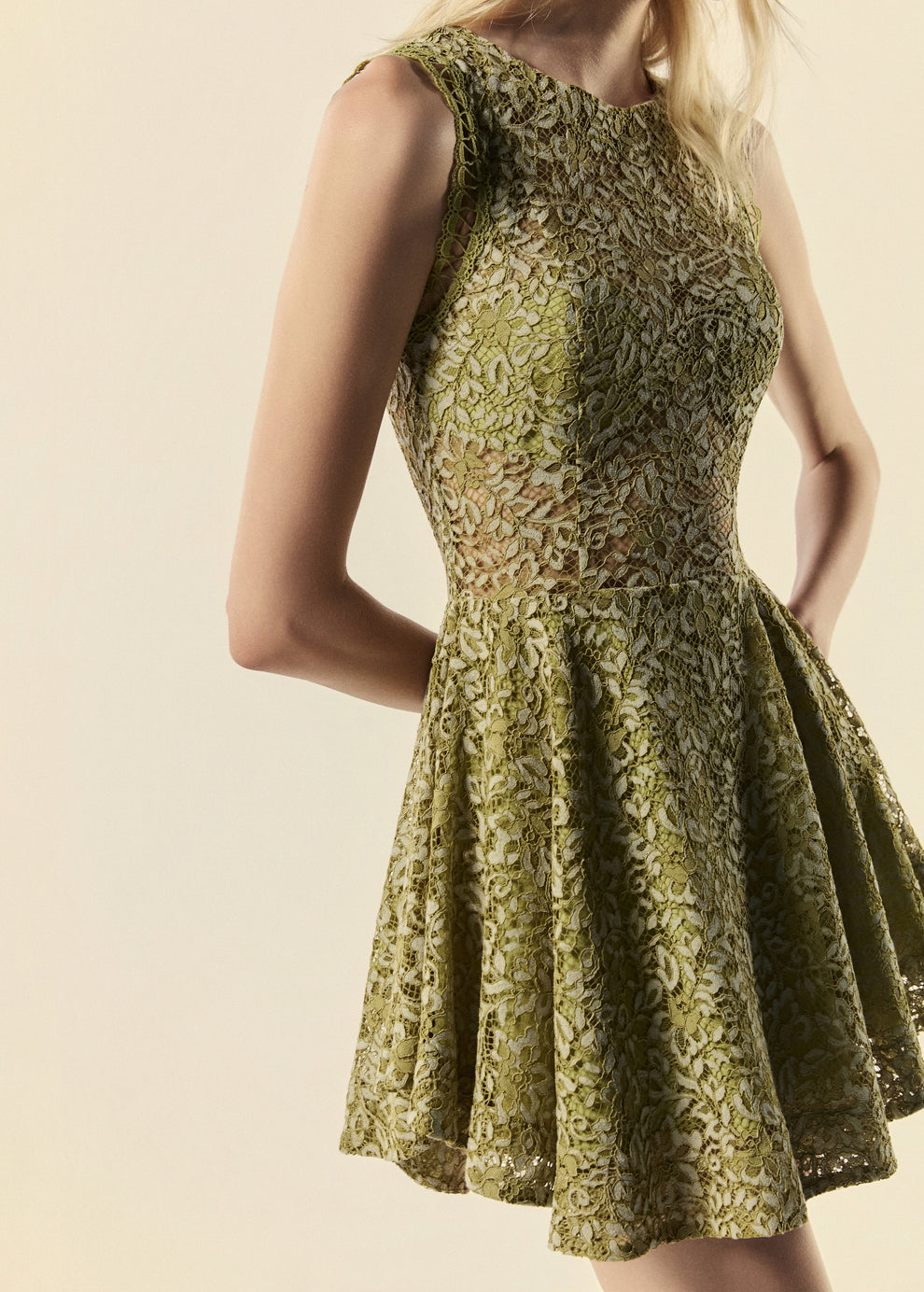 Detalhe lateral do vestido curto de renda verde da família Bosque com movimento da saia evasê.