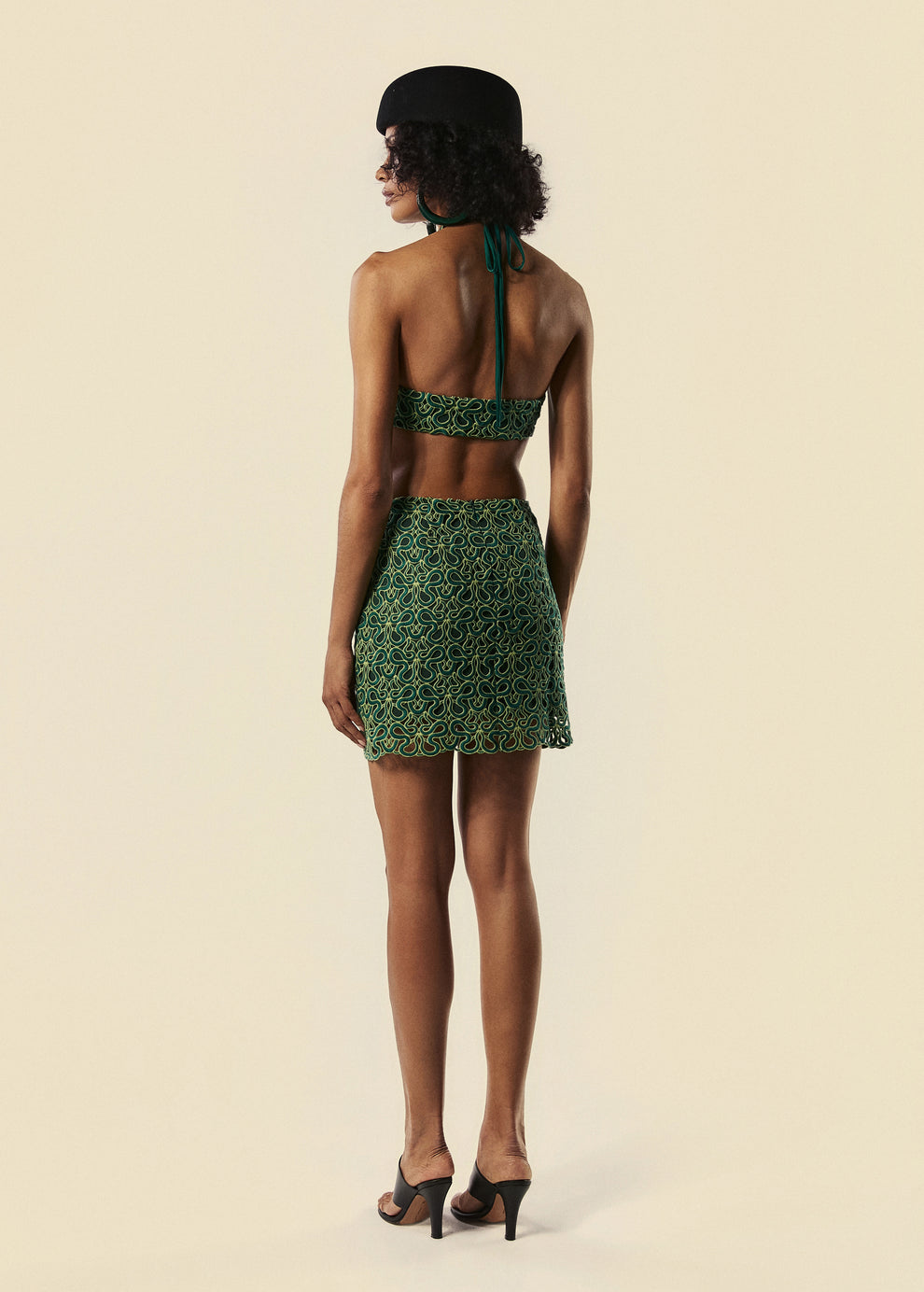 Modelo de costas com vestido curto verde com amarração no pescoço da coleção de Verão 27 da La Gea.