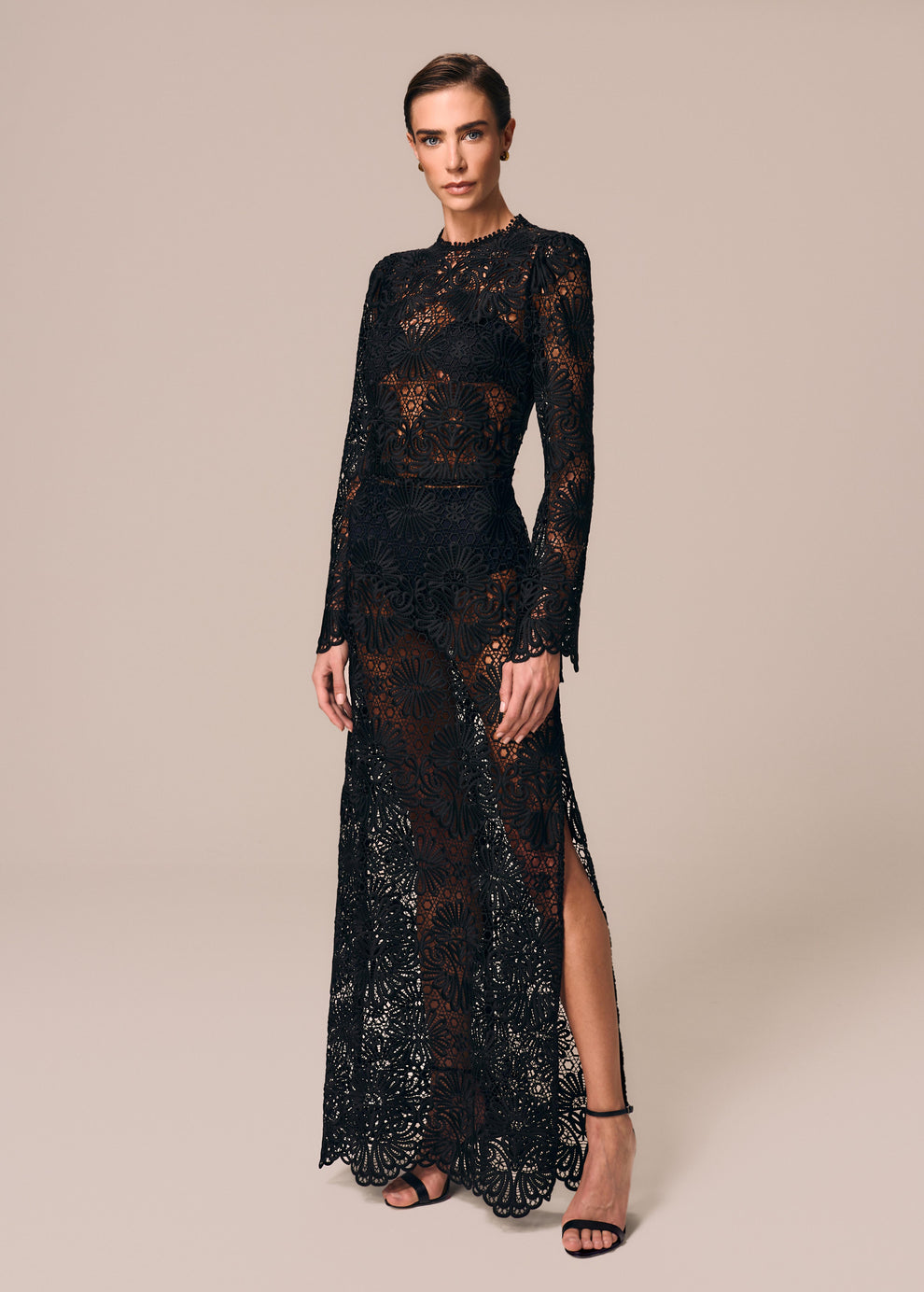 Modelo usa vestido longo em renda com manga longa flare preto Cerâmica La Gea