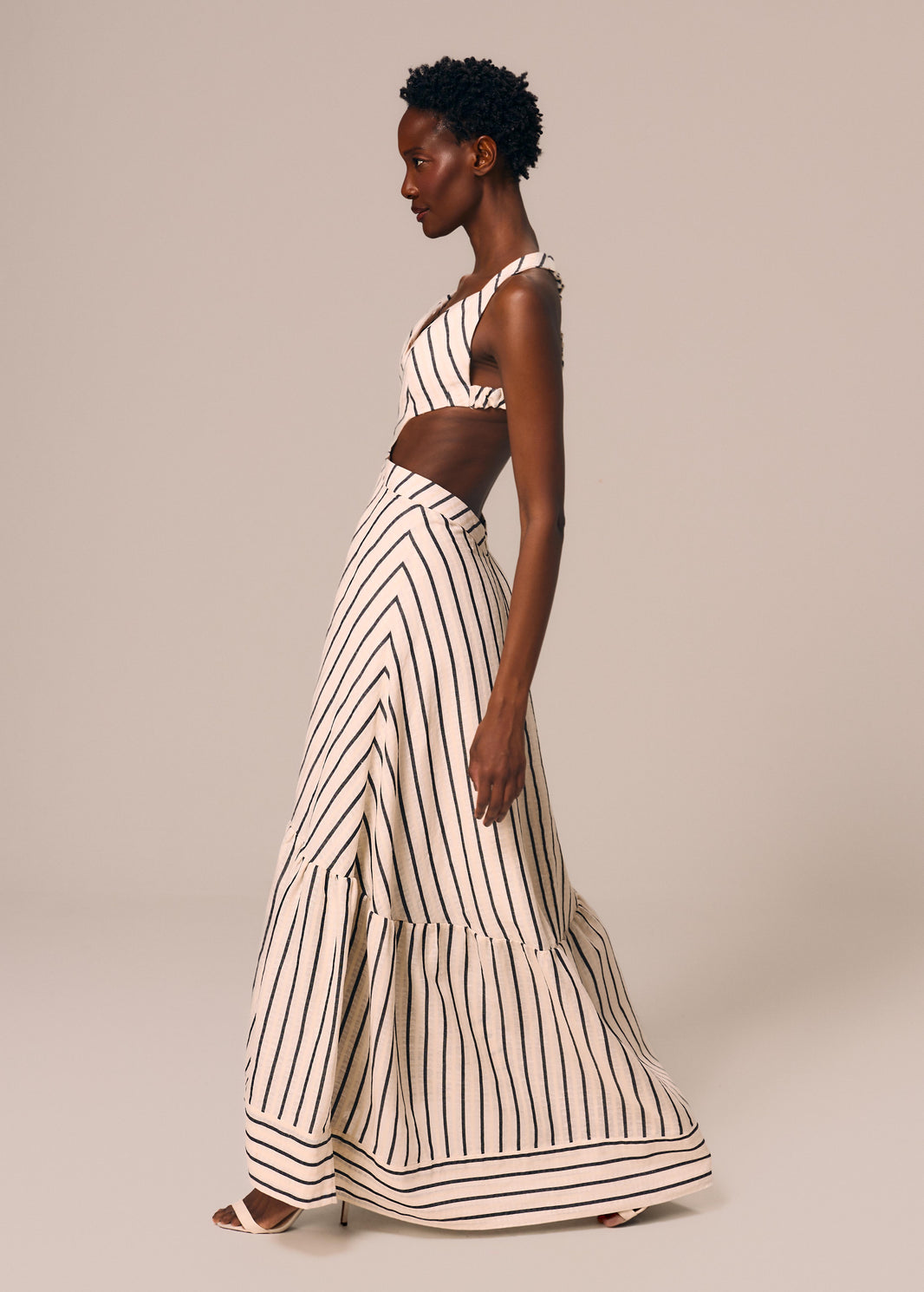 Modelo caminhando usa vestido longo listrado off White e preto Eterno La Gea