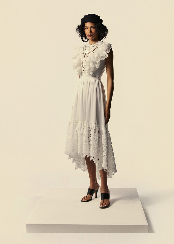 Modelo usa vestido mullet branco em laise com babados Lumina da coleção de Preview de Verão 27 da La Gea.